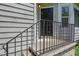 Close-up view of the front door entrance featuring a black door, concrete steps, and a metal railing at 5920 Hampton Ct, College Park, GA 30349