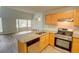 Open kitchen with modern appliances, light wood cabinets, and granite countertops overlooking the living room at 5920 Hampton Ct, College Park, GA 30349