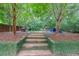 Serene backyard with stone steps leading to inviting seating areas amidst lush greenery, ideal for outdoor enjoyment at 1267 Thomas Rd, Decatur, GA 30030