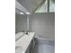 Bathroom featuring double sinks, large mirrors, stylish vanity, and tiled walls with a tub at 311 Indus Ln, Lawrenceville, GA 30044