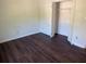 Empty bedroom features dark, laminated wood flooring and a double door closet at 311 Indus Ln, Lawrenceville, GA 30044