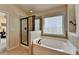 Bright bathroom featuring a soaking tub and glass enclosed shower at 5016 Garrett Ct, Alpharetta, GA 30005