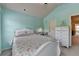 This bedroom features light blue walls, carpet, desk, and a white dresser, complemented by natural light at 5016 Garrett Ct, Alpharetta, GA 30005