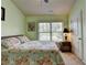 Well-lit bedroom with a nightstand, lamp and large window with blinds at 5016 Garrett Ct, Alpharetta, GA 30005