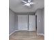 Spacious bedroom featuring a ceiling fan, closet, and entry door with light hardwood floors at 1094 Amber Sw Rdg, Lilburn, GA 30047