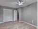 Neutral bedroom with hardwood floors, a ceiling fan, and closet space, creating a serene and comfortable space at 1094 Amber Sw Rdg, Lilburn, GA 30047
