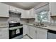 Kitchen featuring white cabinets, granite countertops, stainless steel appliances and modern lighting at 1094 Amber Sw Rdg, Lilburn, GA 30047
