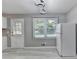 Kitchen area features modern lighting fixture, a refrigerator, and a window providing plenty of natural light at 1094 Amber Sw Rdg, Lilburn, GA 30047
