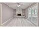 Living room featuring built-in shelving around the fireplace, natural light, and wood-look flooring at 1094 Amber Sw Rdg, Lilburn, GA 30047