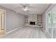 Spacious living room with a decorative stone fireplace, built-in shelves, and sliding glass doors at 1094 Amber Sw Rdg, Lilburn, GA 30047