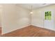 Dining area with hardwood floors, neutral paint, pendant lighting and a glass-paned door to the backyard at 131 Tye St, Stockbridge, GA 30281