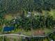 Stunning aerial view of the property showcasing lush forests, open fields, a pond, and the residence at 360 Parr Farm Rd, Covington, GA 30016