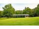 Expansive grassy backyard features a covered structure surrounded by mature trees at 360 Parr Farm Rd, Covington, GA 30016