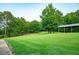 Expansive grassy backyard features a covered structure surrounded by mature trees at 360 Parr Farm Rd, Covington, GA 30016