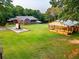 A picturesque barn structure on a sprawling property is framed by lush greenery and the residence at 360 Parr Farm Rd, Covington, GA 30016