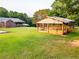 A picturesque barn structure is framed by lush greenery, set against a backdrop of mature trees at 360 Parr Farm Rd, Covington, GA 30016