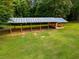 A picturesque barn structure is framed by lush greenery, set against a backdrop of mature trees at 360 Parr Farm Rd, Covington, GA 30016