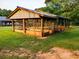 A picturesque barn structure is framed by lush greenery, set against a backdrop of mature trees at 360 Parr Farm Rd, Covington, GA 30016