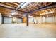 Spacious unfinished basement with concrete floors, open ceiling with exposed beams, and garage doors at 360 Parr Farm Rd, Covington, GA 30016