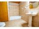 A tiled bathroom features a tub, shower, pedestal sink, and warm, neutral color scheme at 360 Parr Farm Rd, Covington, GA 30016
