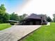 Exterior home view with a wide driveway and ample parking, featuring a covered carport and lush green lawn at 360 Parr Farm Rd, Covington, GA 30016