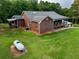 Aerial view of a brick home with a covered porch and expansive green lawn at 360 Parr Farm Rd, Covington, GA 30016