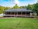 Inviting home featuring a full, covered porch with wooden railings, complemented by a lush green lawn at 360 Parr Farm Rd, Covington, GA 30016
