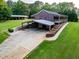 Large lot featuring a ranch-style home with carport and spacious driveway, all surrounded by lush greenery at 360 Parr Farm Rd, Covington, GA 30016