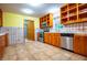Galley kitchen with tile backsplash and floors, wooden cabinets and stainless appliances at 360 Parr Farm Rd, Covington, GA 30016