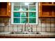 Close-up of the kitchen sink featuring a window and tiled backsplash at 360 Parr Farm Rd, Covington, GA 30016