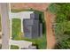 An aerial rooftop view of a modern home featuring a dark roof, verdant lawn, and driveway in a planned community at 6120 Hutchins Dr, Buford, GA 30518