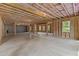 Spacious unfinished basement with natural light, wood framing, and concrete flooring at 6120 Hutchins Dr, Buford, GA 30518