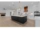 Stunning kitchen with large island, custom cabinets, wood accents, stainless appliances, and hardwood floors at 6120 Hutchins Dr, Buford, GA 30518