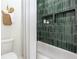 Bathroom with shower-tub combo, verdant tiled walls, and built-in shower niche at 1168 Mado Loop, Chattahoochee Hills, GA 30268