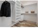 Walk-in closet with custom shelving and wood floors at 1168 Mado Loop, Chattahoochee Hills, GA 30268
