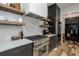 Modern kitchen features stainless steel appliances, custom cabinets, and floating shelves for a sleek design at 1168 Mado Loop, Chattahoochee Hills, GA 30268