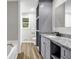Bathroom with a large granite countertop, neutral grey walls, a large mirror and a tub shower at 3927 Airline Rd, Mcdonough, GA 30252