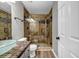 Bathroom featuring a glass shower, decorative sink, tiled wall and wooden laminate flooring at 3927 Airline Rd, Mcdonough, GA 30252