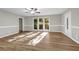 Sunlit living room featuring wood floors, wainscoting, and large windows overlooking the backyard at 3927 Airline Rd, Mcdonough, GA 30252