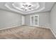 Large main bedroom with tray ceiling, carpet and doors to the outside at 3927 Airline Rd, Mcdonough, GA 30252