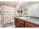 Well-lit bathroom featuring a floral shower curtain, vanity with dark cabinets, and a speckled countertop at 7052 Camp Falls Ct, Winston, GA 30187