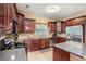 Well-equipped kitchen with stainless steel appliances, granite countertops, dark wood cabinets, and tiled backsplash at 7052 Camp Falls Ct, Winston, GA 30187