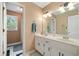 Traditional bathroom with double sinks, white cabinets, and a shower/tub combo with a window for natural light at 1039 Avery Creek Dr, Woodstock, GA 30188