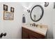Charming half bathroom with a decorative mirror, unique wall art, and a vanity with a dark wood cabinet at 1039 Avery Creek Dr, Woodstock, GA 30188