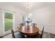 Formal dining room with chandelier, wood table, and large window offering backyard views at 1039 Avery Creek Dr, Woodstock, GA 30188