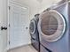 Functional laundry room with modern washer and dryer, plus a white door at 423 Livingston Pt, Acworth, GA 30102