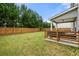 Spacious backyard featuring a well-maintained lawn, wooden fence, and covered patio area at 2680 Lower Village Dr, Ellenwood, GA 30294