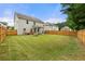 Expansive fenced backyard featuring a well-manicured lawn, a covered patio, and mature trees at 2680 Lower Village Dr, Ellenwood, GA 30294