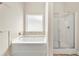 Bright bathroom with a tub, separate shower, and neutral-toned tile accents at 2680 Lower Village Dr, Ellenwood, GA 30294