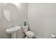 Bathroom featuring a pedestal sink, a round mirror, a toilet, and neutral decor at 2680 Lower Village Dr, Ellenwood, GA 30294